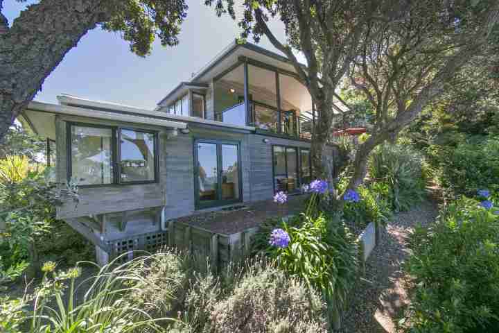 Front of beachfront family home and garden path leading to Enclosure Bay