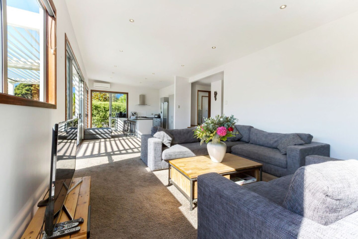 Stay in open plan comfort at Karaka with large couches, TV, coffee table and deck access