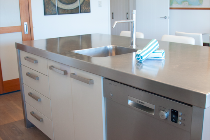 Breakfast bar in kitchen featuring dishwasher at modern Onetangi apartment