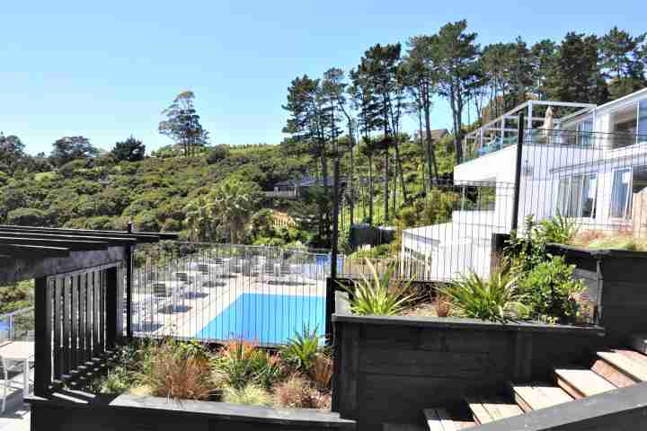 Sunny outdoor pool with loungers, outdoor seating and beach view