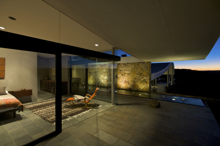 Bedroom with glass front and expansive views of Australian bush at the iconic Seidler House, private contemporary luxury holiday accommodation in Australia Southern Highlands