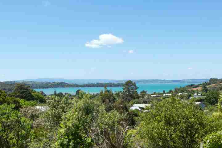 Enjoy sea views from deck at Tiri Cottage, walking distance from Oneroa village