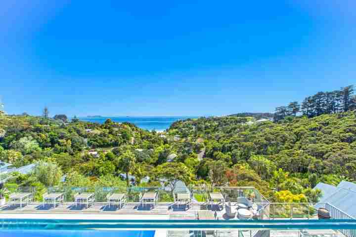 Sunny outdoor infinity pool with loungers at The Resort, Palm Beach